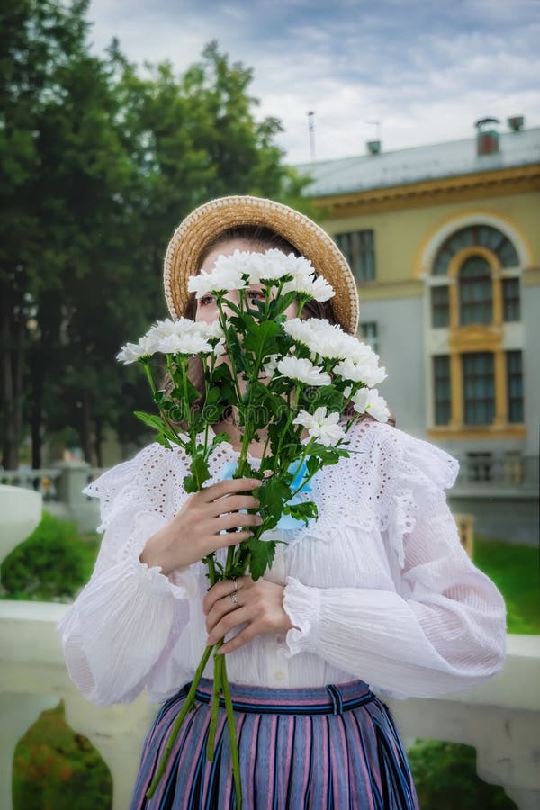 Portrait fille avec un bouquet de chrysanthèmes blancs en vêtements vintage image stock