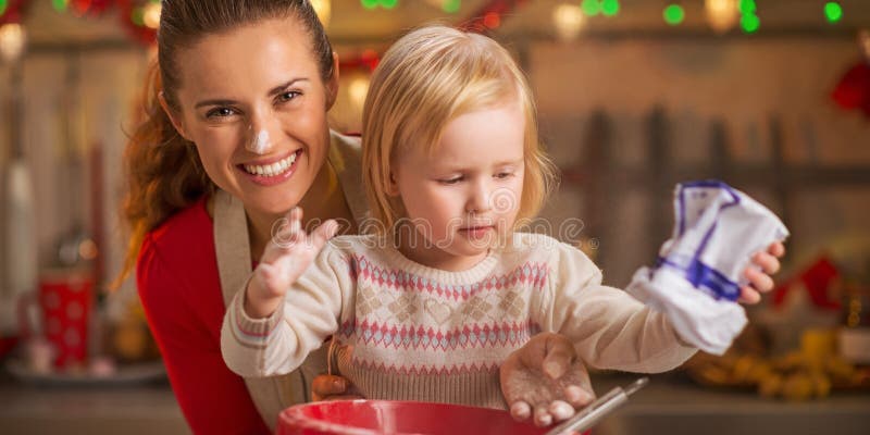 Portrait of flour smeared mother and baby making cookies stock photo Portrait of flour smeared mother and baby making cookies stock photo
