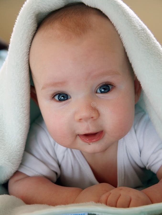 Portrait of four months old sweet baby. A beautiful smiling and drooling baby wrapped in a furry blanket. Portrait of four months old sweet baby. A beautiful smiling and drooling baby wrapped in a furry blanket.