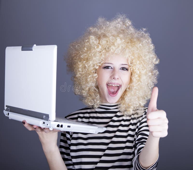 Portrait of funny girl in blonde wig with laptop.