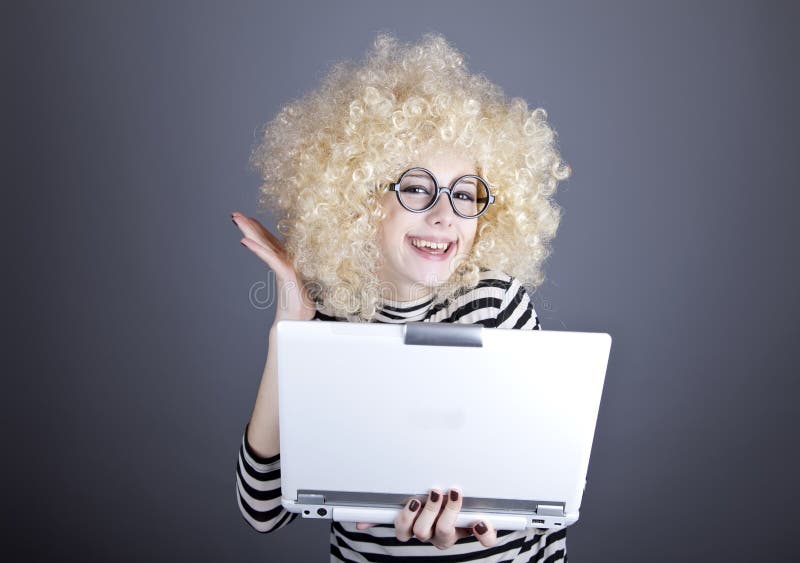 Portrait of funny girl in blonde wig with laptop.