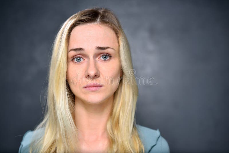 Skinny Blonde Girl In Gray Dress On The Background Of Gray Wall Stock