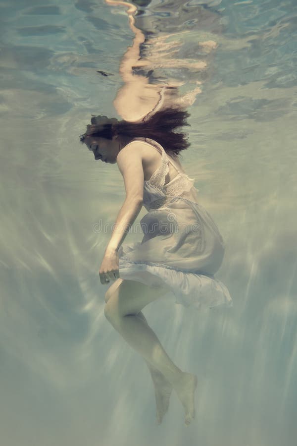 Photos of a young girl swimming underwater in a light blue dress creating the effect of weightlessness and lightness. Photos of a young girl swimming underwater in a light blue dress creating the effect of weightlessness and lightness.