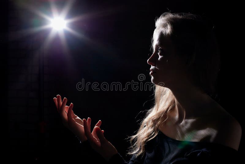 Portrait of a girl illuminated by the contour light of a flash on a black background