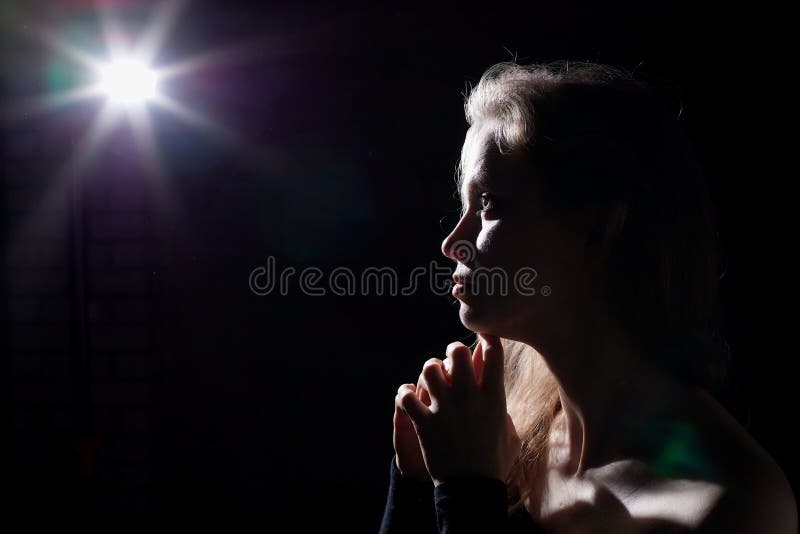 Portrait of a girl illuminated by the contour light of a flash on a black background