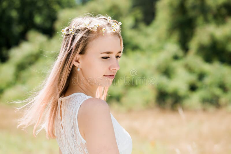 Portrait of a girl with pink hair decorated with little daisies, close-up