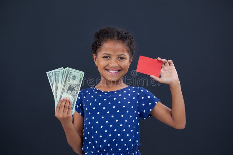 Portrait of girl showing credit card and currency stock photo Portrait of girl showing credit card and currency stock photo