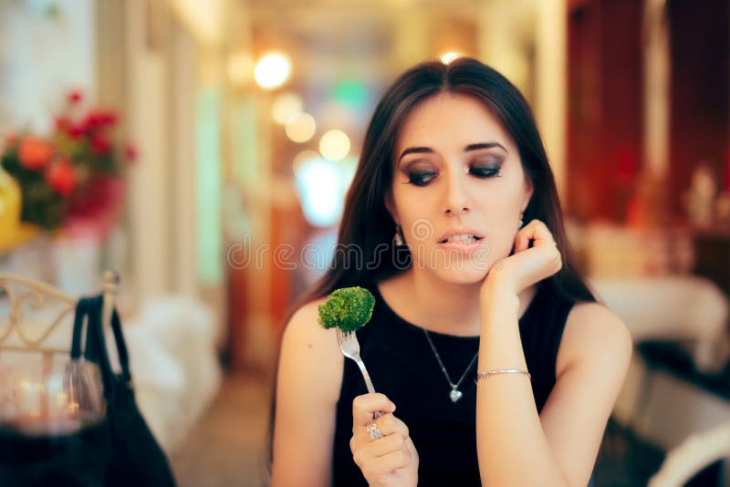 Portrait of a girl trying a diet vegetarian dish at formal dinner. Portrait of a girl trying a diet vegetarian dish at formal dinner