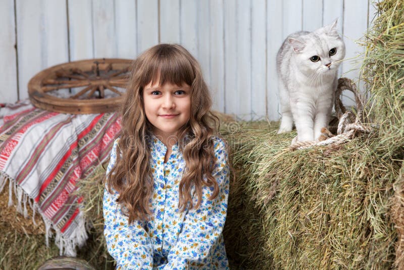 Portrait girl villager, cat on hay stack in barn