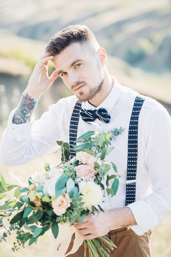 Portrait of a groom in bow tie at the wedding in nature.