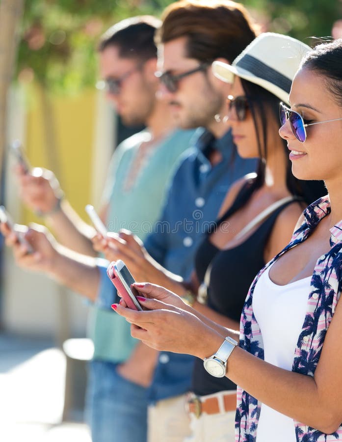 Portrait of group of friends having fun with smartphones.