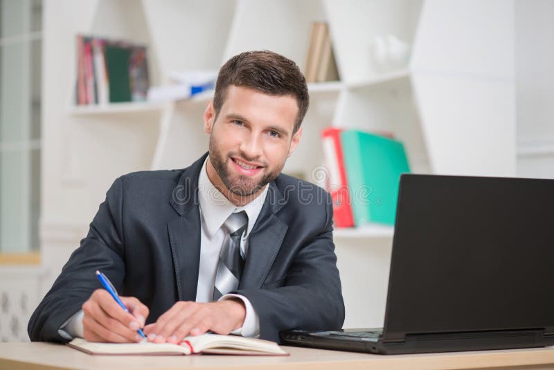 Portrait of handsome confident businessman writing stock photo Portrait of handsome confident businessman writing stock photo