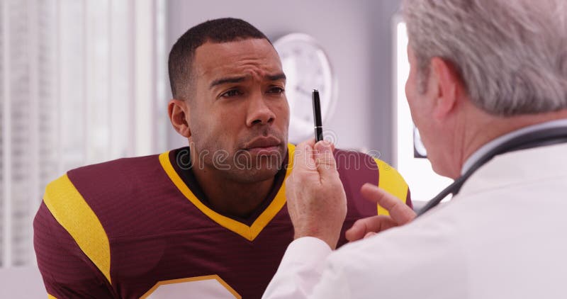 Portrait of handsome football player consulting sports injury with a doctor.
