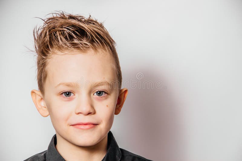 Cute guy in a black shirt smiles on a white background. Face close up