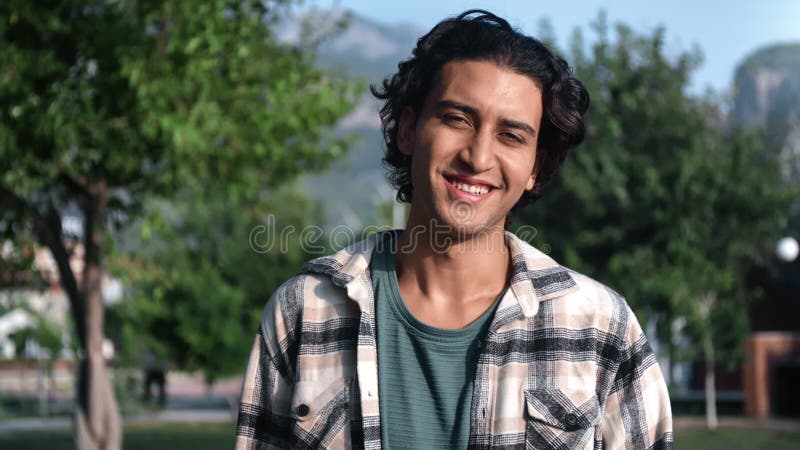Portrait handsome smiling Latino guy posing outdoor at mountain scenery park with positive emotion stock video footage