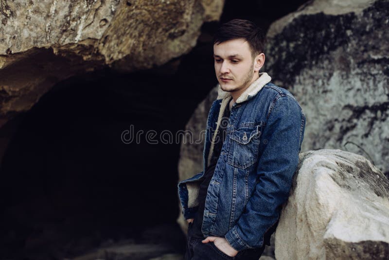 Portrait of a handsome young man in a denim jacket outdoors royalty free stock photo