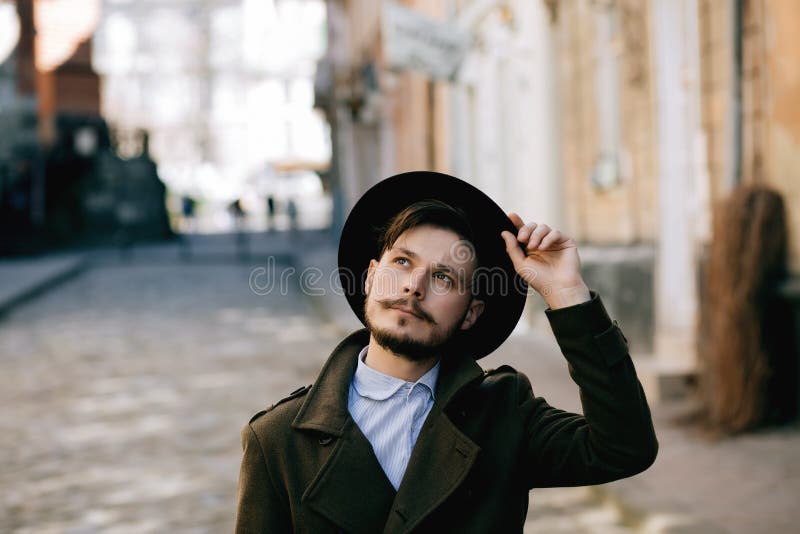 Portrait of a handsome young man with a mustache in a hat royalty free stock image