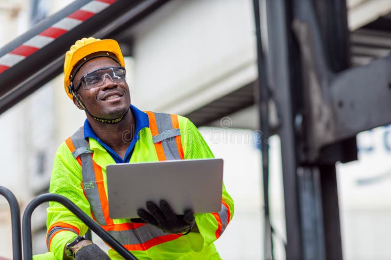 Portret: lucrător negru african fericit în industria transportului maritim portport de marfă cu vestă de siguranță tare. supravegh stock photos