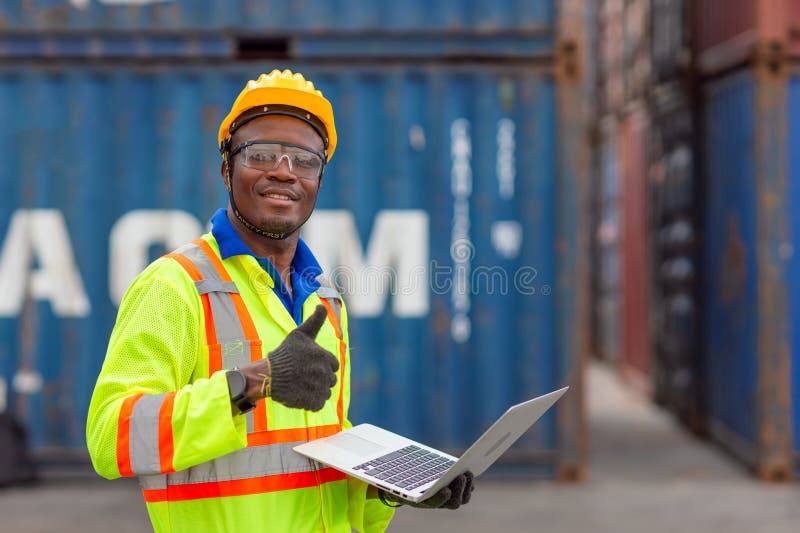 Portret: lucrător negru african fericit în industria transportului maritim portport de marfă cu vestă de siguranță tare. supravegh stock image