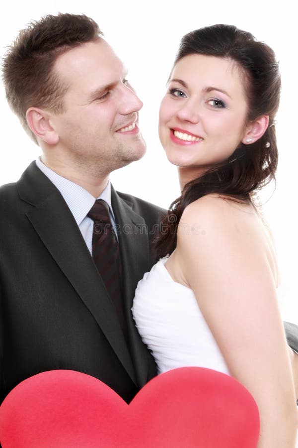 Portrait of happy bride and groom with red heart