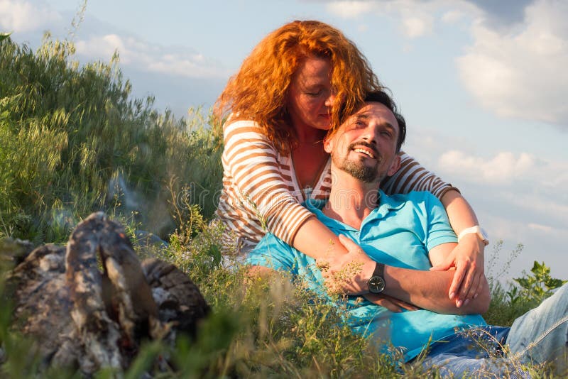 Portrait Of Happy Couple Laying On Blanket on grass near fireplace on clouds background royalty free stock photos Portrait Of Happy Couple Laying On Blanket on grass near fireplace on clouds background royalty free stock photos