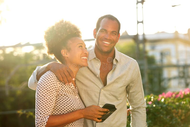 Happy couple standing outside with woman holding phone royalty free stock images Happy couple standing outside with woman holding phone royalty free stock images