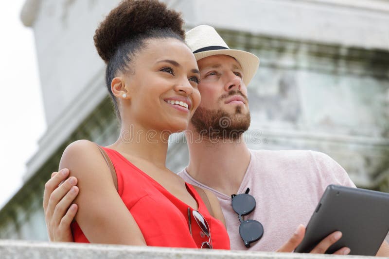 Portrait happy couple using digital tablet in city stock photos Portrait happy couple using digital tablet in city stock photos
