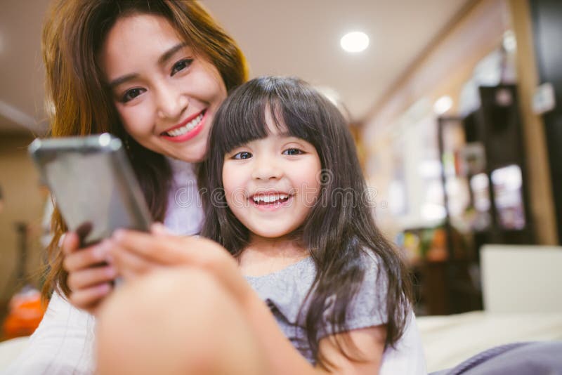 Portrait Happy Daughter playing smartphone with her mother. stock image Portrait Happy Daughter playing smartphone with her mother. stock image