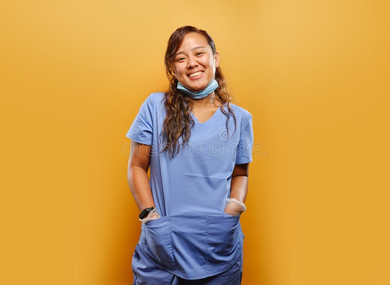 Portrait of happy filipina nurse. On orange background