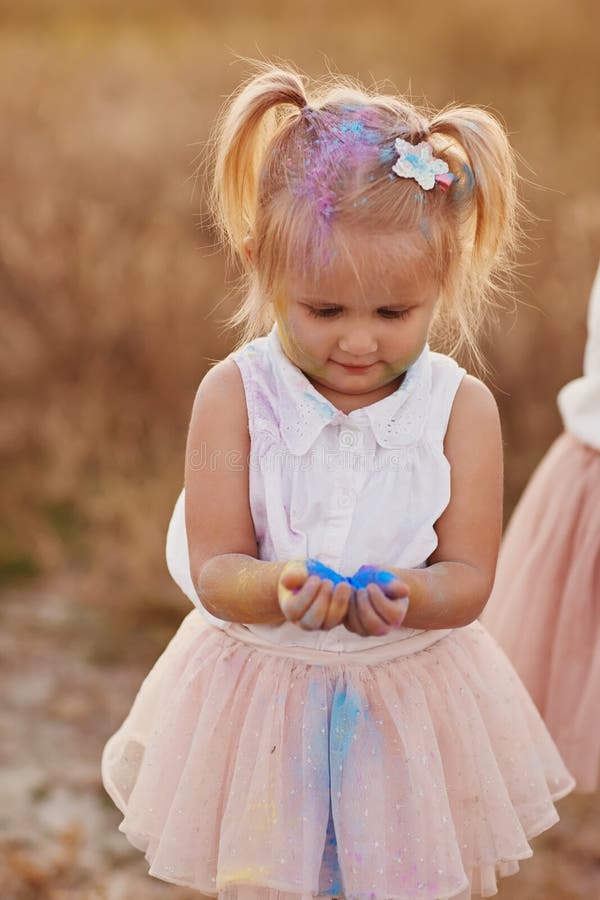 Portrait of happy girl smeared with colored powder. little girl with two tails stock photos Portrait of happy girl smeared with colored powder. little girl with two tails stock photos