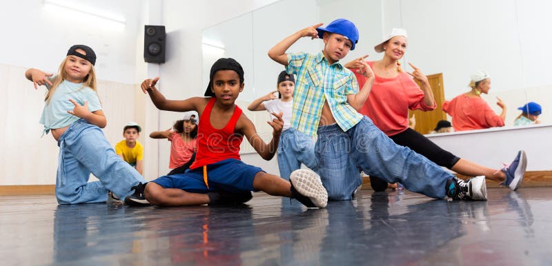 Portrait of happy girls and boys hip hop dancers and women instructor posing during group dance workout. Portrait of happy girls and boys hip hop dancers and women instructor posing during group dance workout