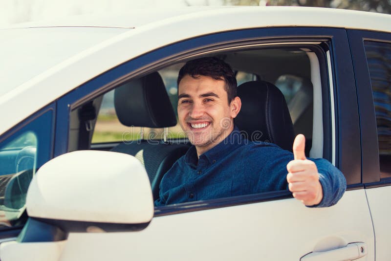 Portrait of happy guy, uber driver showing thumb up positive gesture, smiling gently to camera