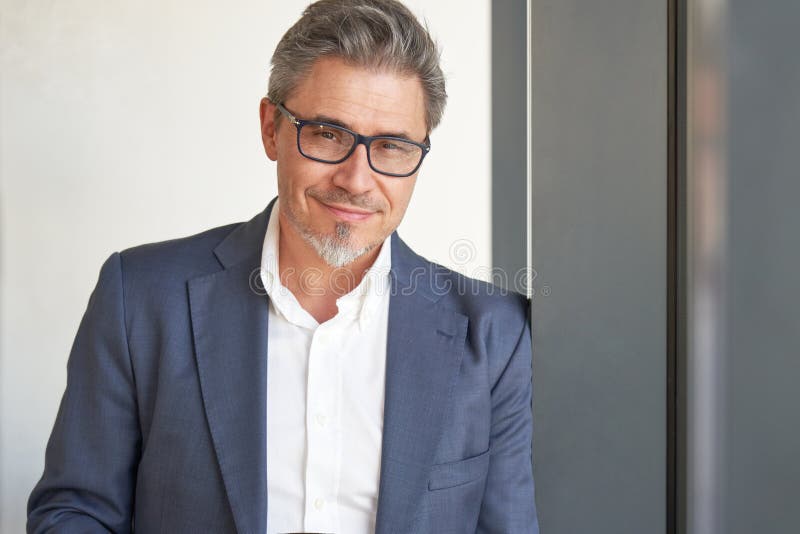 Portrait of happy handsome man wearing glasses, looking at camera. Confident businessman in suit, using tablet