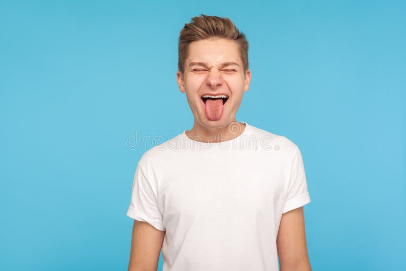 Portrait of happy humorous man in casual white t-shirt showing funny grimace and sticking out tongue stock images Portrait of happy humorous man in casual white t-shirt showing funny grimace and sticking out tongue stock images