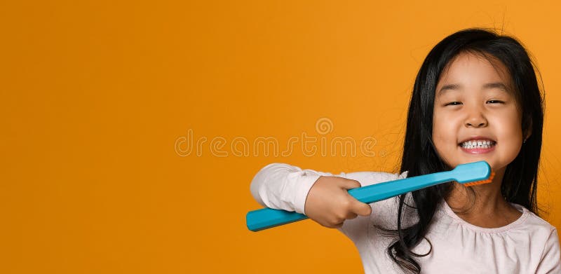 Portrait of a little girl holding a tooth brush over yellow background royalty free stock photos Portrait of a little girl holding a tooth brush over yellow background royalty free stock photos