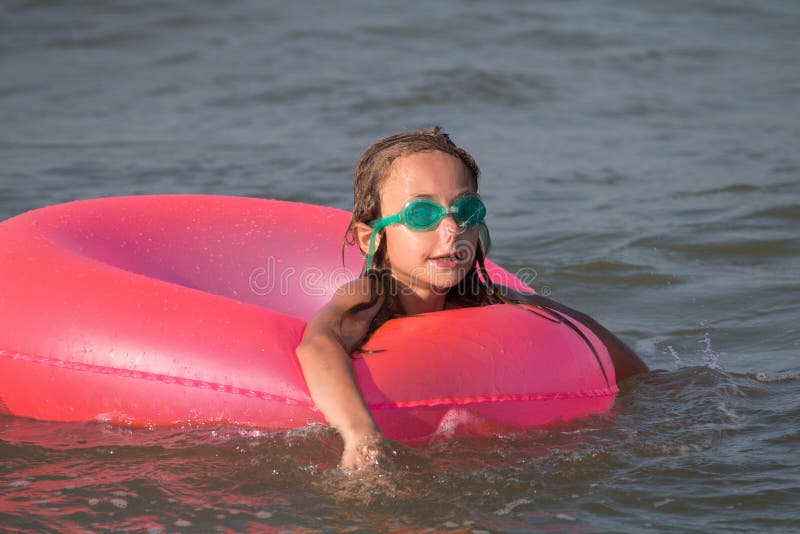Portrait, Happy Little Girl Swims in the Sea on an Inflatable Circle ...