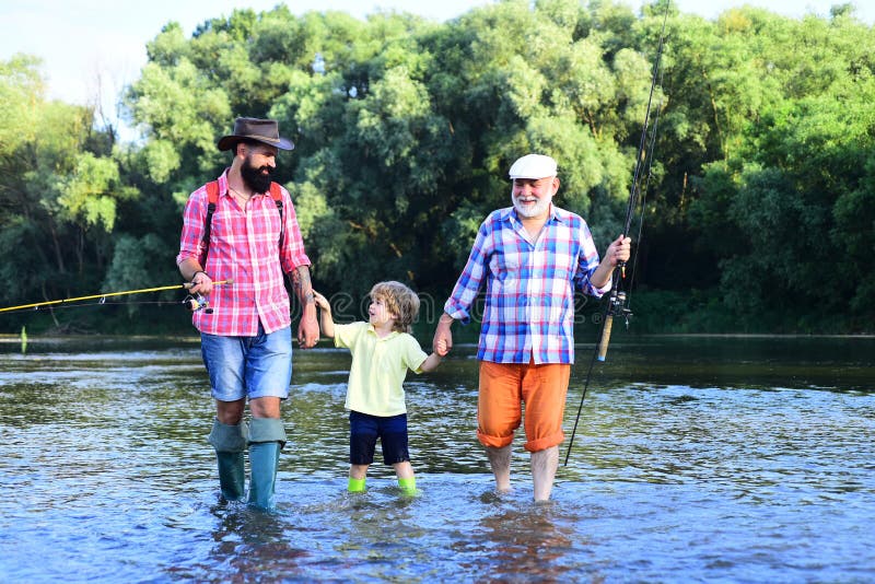 Portrait of happy little son, father and grandfather - three generations of men fishing on river. Happy fisherman with