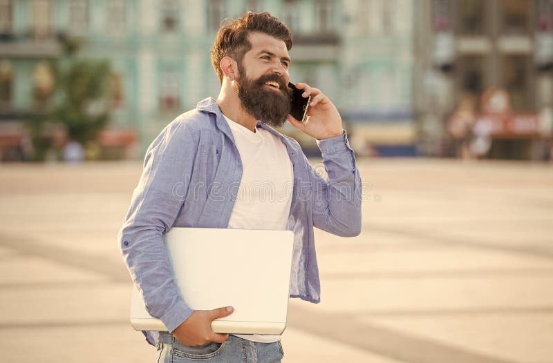Portrait of happy man talking on mobile phone. Smiling man making mobile call walking in street royalty free stock photography
