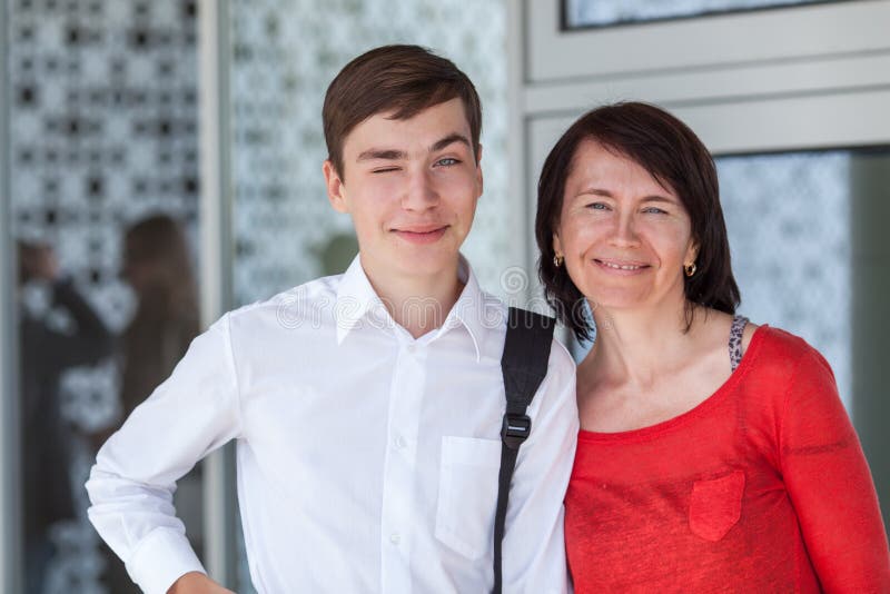 Portrait of happy mather with son on white wall