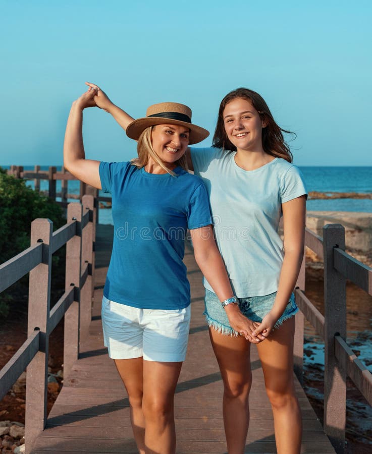 Teen girl in t-shirt standing and holding reusable water bottle in