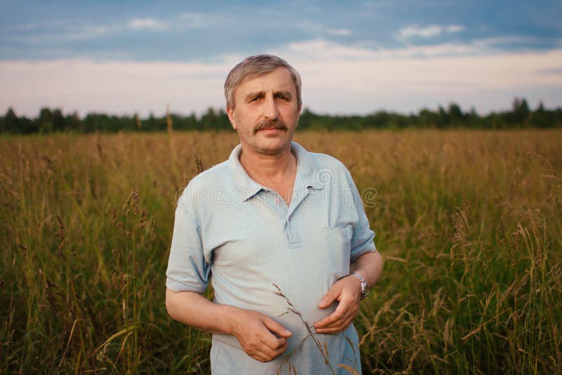 Portrait happy old Elderly male having fun, on field in village. Healthcare lifestyle senior man relax in summertime