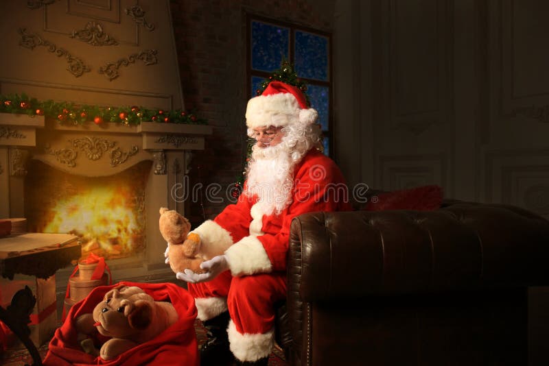 Portrait of happy Santa Claus sitting at his room at home near Christmas tree and reading Christmas letter or wish list. royalty free stock images Portrait of happy Santa Claus sitting at his room at home near Christmas tree and reading Christmas letter or wish list. royalty free stock images