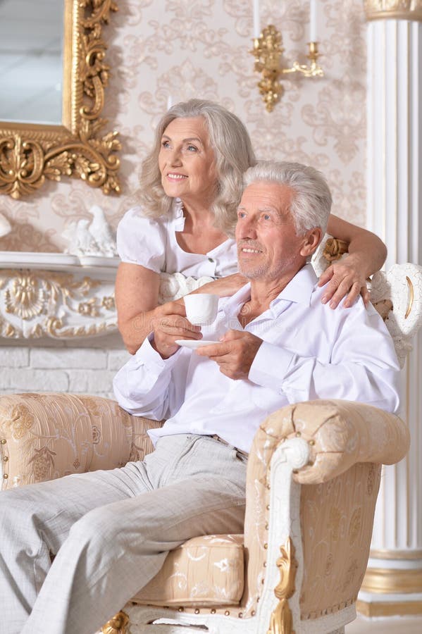 Portrait of happy senior couple drinking tea in cozy living room stock image Portrait of happy senior couple drinking tea in cozy living room stock image