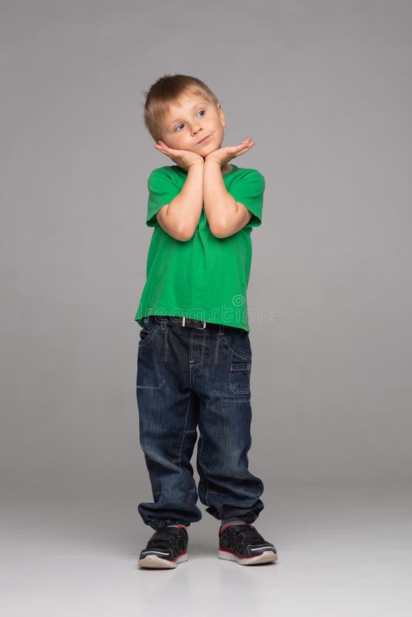 Portrait of happy smiling boy in green t-shirt and jeans. Attractive kid in studio. stock images Portrait of happy smiling boy in green t-shirt and jeans. Attractive kid in studio. stock images