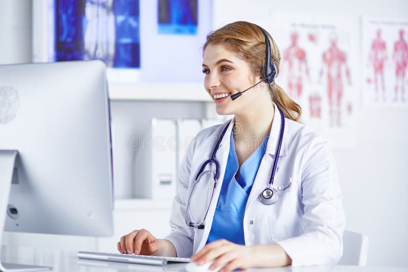 Portrait of a happy smiling young doctor in headset in office.