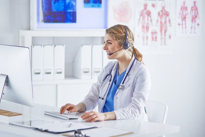 Portrait of a happy smiling young doctor in headset in office.