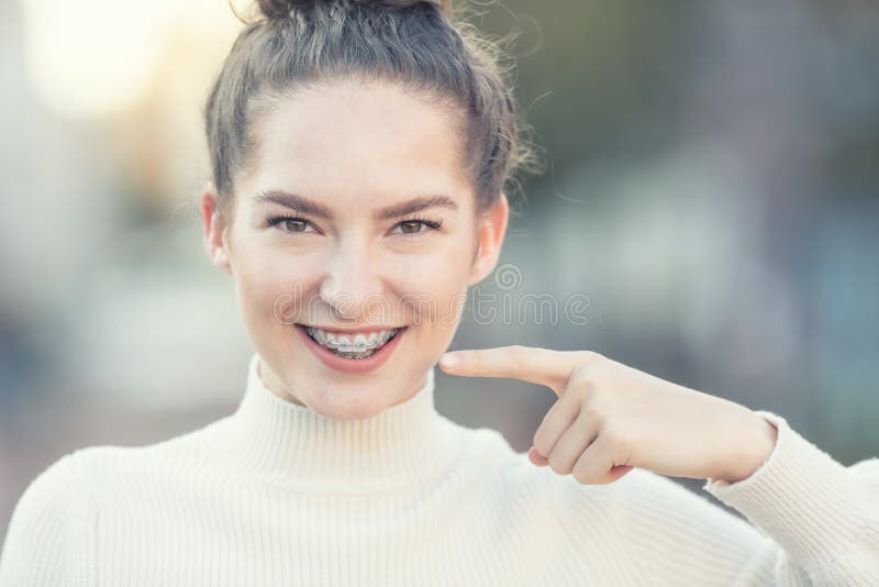 Portrait of a happy smiling young woman with dental braces