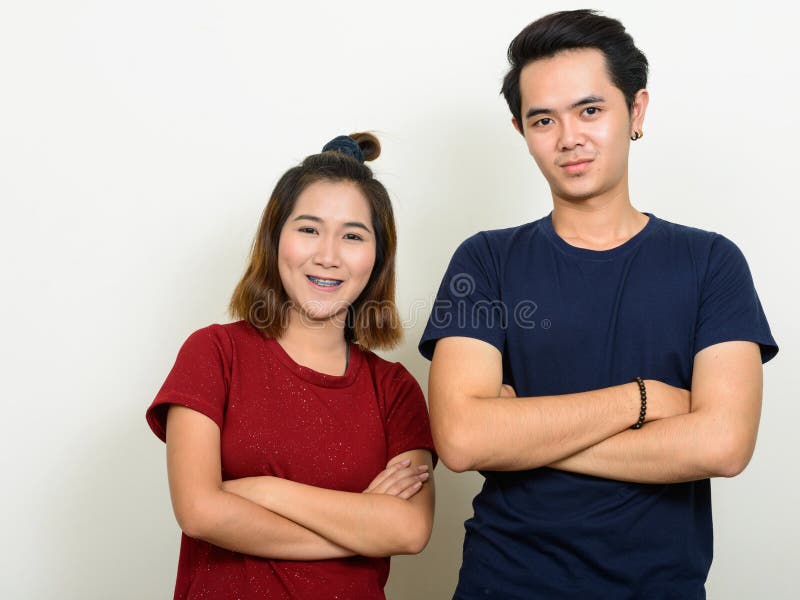 Portrait Of Happy Young Asian Couple Smiling With Arms Crossed Togethe