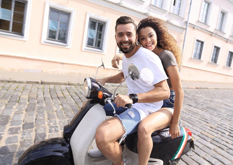 Cheerful Young Couple Riding a Scooter and Having Fun Stock Photo ...