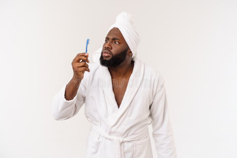 Portrait of a happy young dark-anm brushing his teeth with black toothpaste on a white background. royalty free stock photos Portrait of a happy young dark-anm brushing his teeth with black toothpaste on a white background. royalty free stock photos